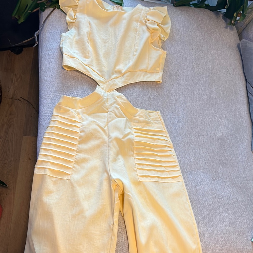 Large pale yellow one piece jumpsuit with back zip detail. Polyester. Tiny holes